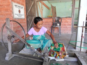 As part of the pre-weaving process, a ‘spinner’ wraps yarn on small bobbins using a home-made spinning contraption made from the metal frame of a cycle wheel.