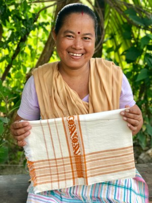 Onima, a Bodo woman living in a small village on the outskirts of Manas National Park, near the India-Bhutan border, poses with a gomosa (a multipurpose shawl-like garment), she has woven herself. A traditional gomosa is white with red motifs, and serves many cultural purposes. It is also offered to guests as a sign of welcome. This gomosa woven by Onima (off-white with ochre woven into it) is a departure from the traditional.