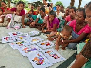 A group of village women study posters depicting acceptable and unacceptable behaviour, as part of the ‘Stop Domestic Violence’ program organized by ‘the ant’.